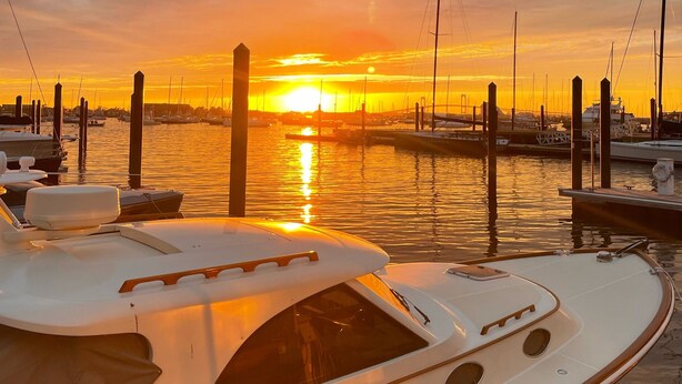 Een jachthaven met boten afgemeerd in de zonsondergang.