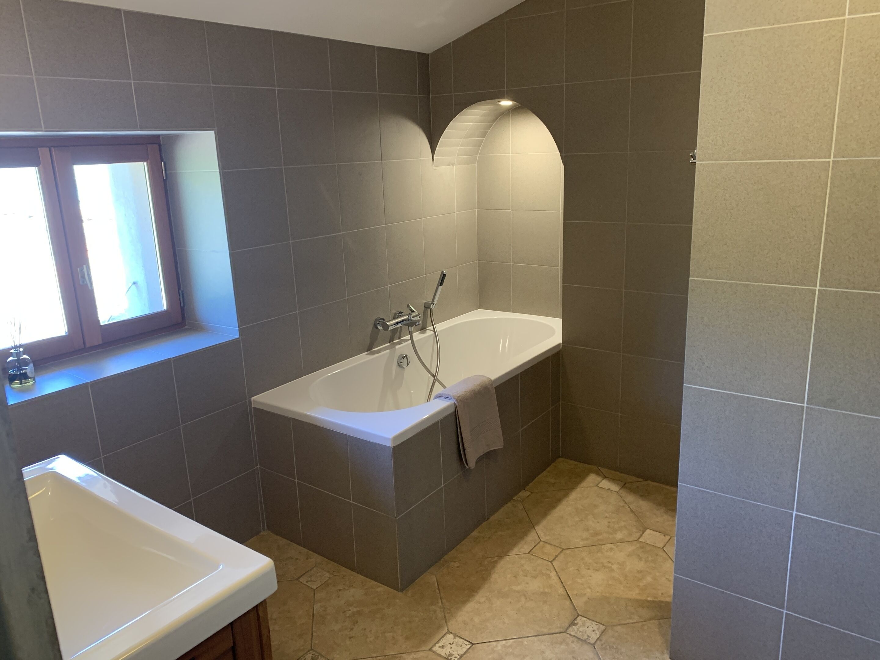 Une salle de bain moderne avec une baignoire sur pieds, une fenêtre et un lavabo.
