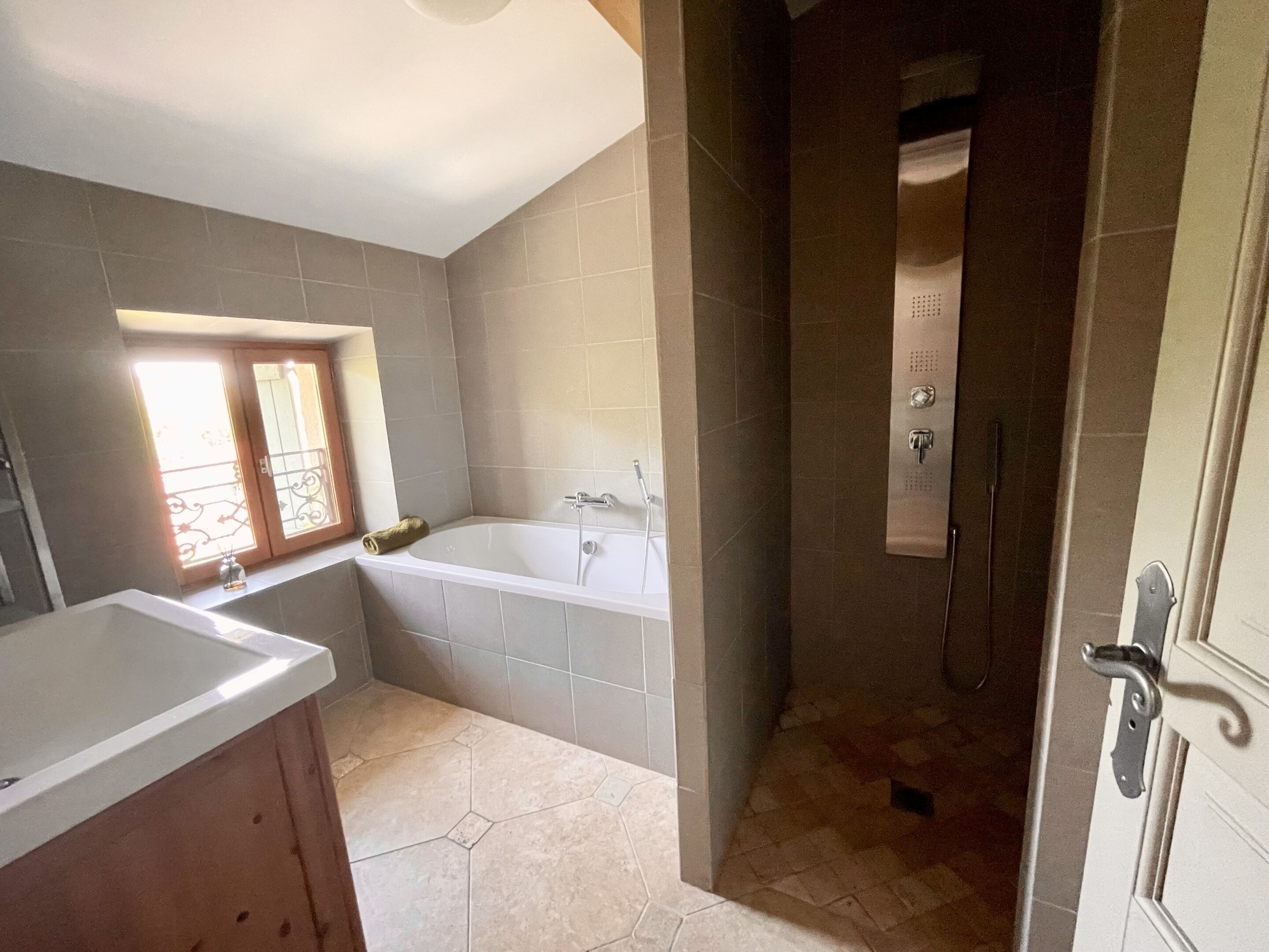 Een badkamer met een bad, douche en wastafel.