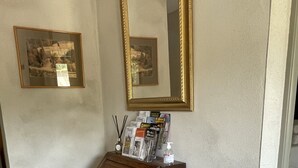 Une commode en bois avec des tiroirs, un miroir et un porte-revues contenant divers objets.
