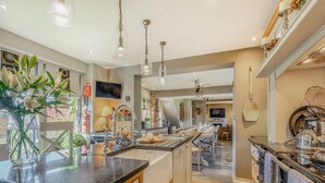 A spacious kitchen with a large island, modern appliances, and a dining area with a view. - 8 bedroom accommodation in Horsemans Green (Horsemans Green)