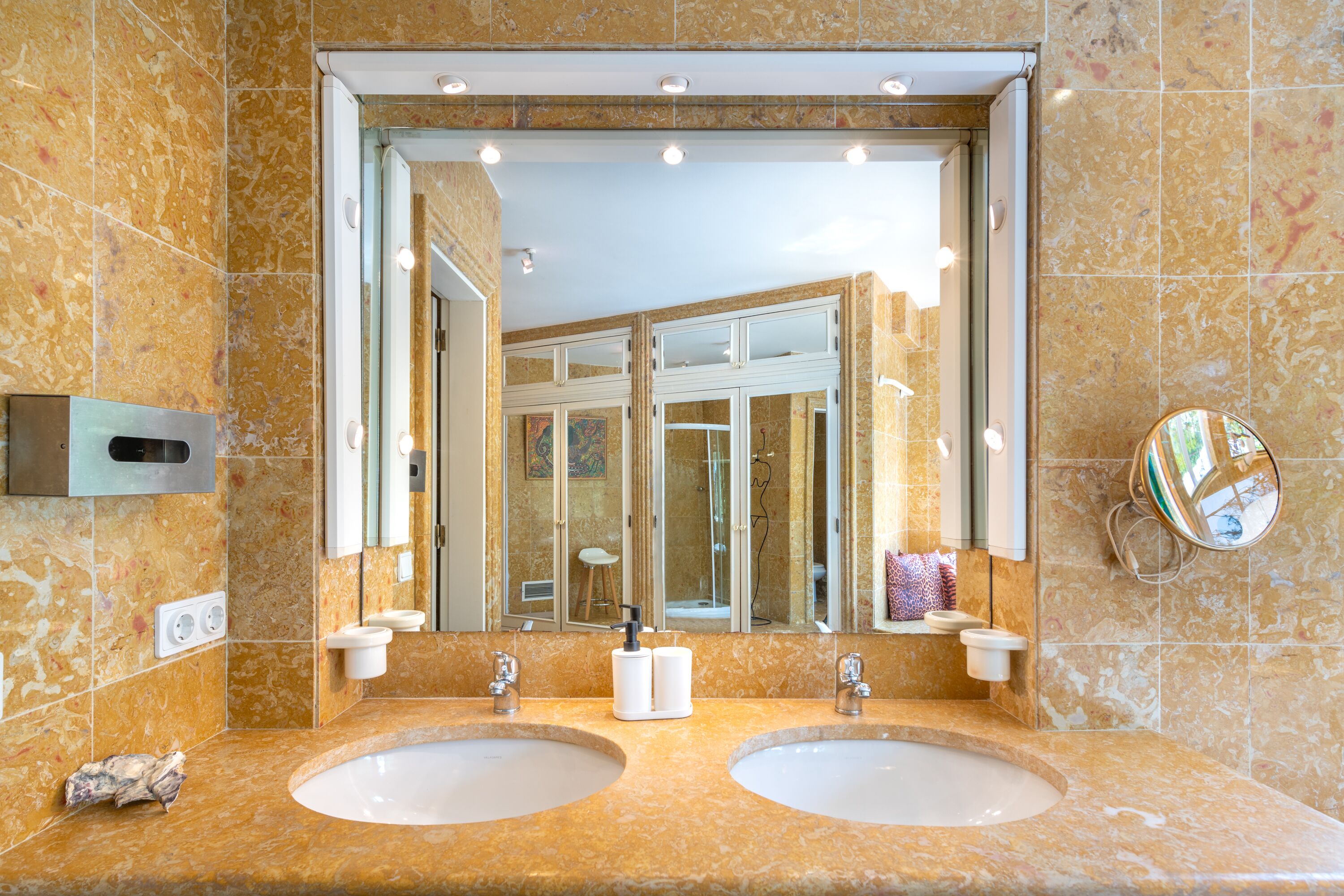 A bathroom with two sinks, a large mirror, and a shower.