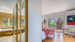 Une salle de bain moderne avec une baignoire, une douche à l’italienne et une grande fenêtre.