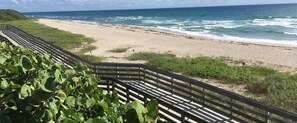 Une plage avec une promenade en bois qui mène au bord de l’eau.