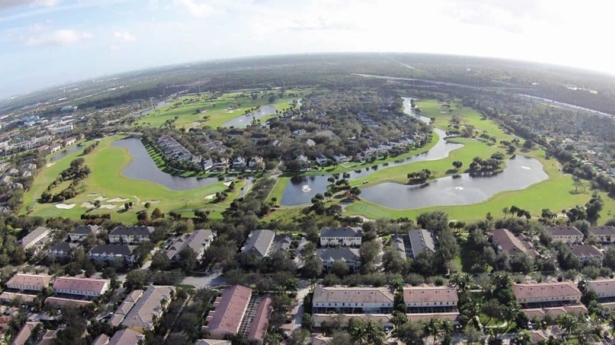 Luchtbeeld van een golfbaan met meerdere vijvers, omringd door woongebouwen.