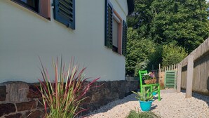 Un jardín con plantas en macetas y piedras decorativas.