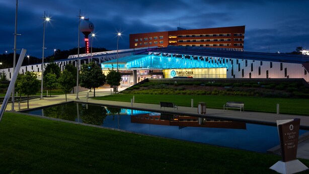 Een modern gebouw met een glazen gevel en een bord voor Turtle Creek Casino & Resort.