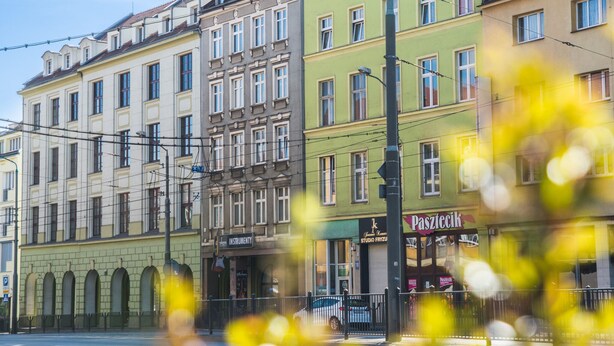 A row of multi-story buildings with various storefronts, including a visible sign for 'Pasztycik'. - Apartment Centrum (Szczecin)