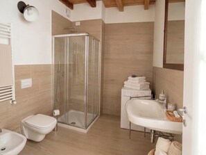 A modern bathroom with a glass-enclosed shower, a toilet, a bidet, and a sink with a mirror. - Borgovivobg Apt2 Apartment Bergamo City Center (Bergamo)