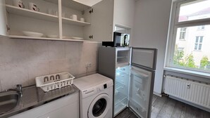 A compact kitchen with a washing machine, a refrigerator, and a microwave. - New flat for 9 ★Special price per month ★ 4 Rooms (Zeitz)
