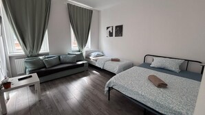 A bedroom with a sofa bed, two single beds, a bedside table, and a window with curtains. - New flat for 9 ★Special price per month ★ 4 Rooms (Zeitz)
