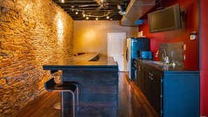 A kitchen with a stone wall, wooden floor, and modern appliances.