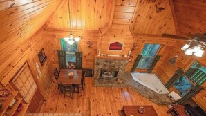 A cabin interior with a dining area, fireplace, and a bathtub. - Cherokee private cabin in Riverside Resort (Benton)