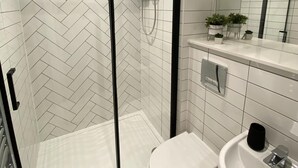 A modern bathroom with a glass-enclosed shower, a white toilet, and a sink. - Kempston Suites Liverpool Apartment 3 (Liverpool)
