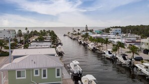 Boats docked along a tranquil waterway, surrounded by palm trees and residential buildings.