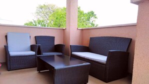 A balcony with wicker furniture, including a sofa and chairs, and a small table. - Cottage for 6 persons in Bale near Rovinj (Bale)