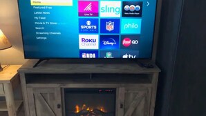 A television displaying a Roku TV interface with various streaming options. - Cedar Mountain - Suite B (Grants Pass)