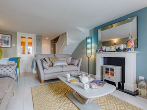 Un salon avec un canapé, une table basse et une cheminée.