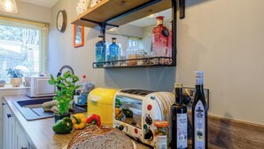 A kitchen with a toaster, a bottle of balsamic vinegar, and a jar of olives. - 2 bedroom accommodation in Reedham (Reedham)