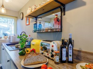 Une cuisine équipée d’un grille-pain, d’une bouteille de vinaigre balsamique et d’un bocal d’olives.