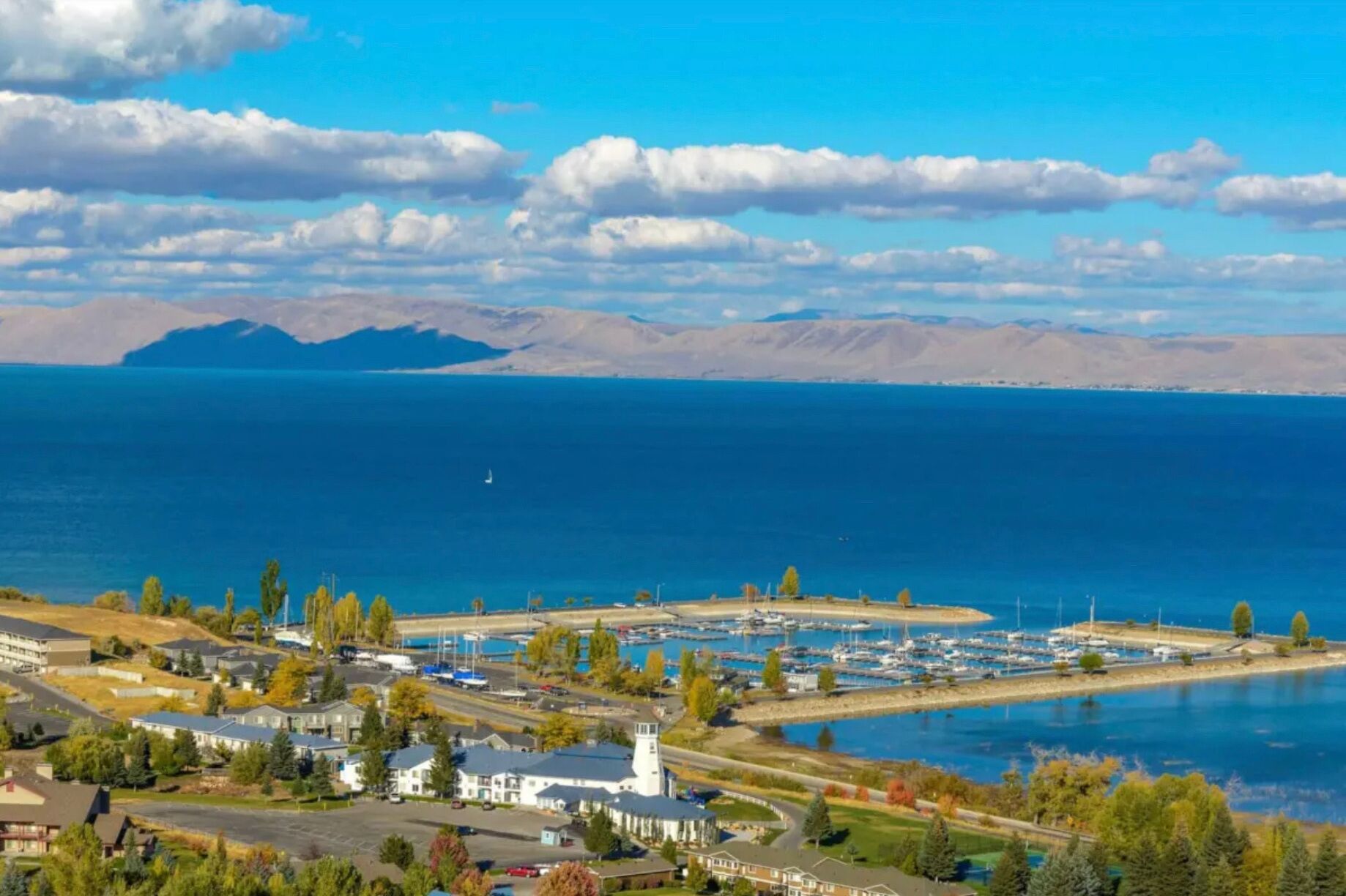 A coastal town with a marina, residential buildings, and a church.