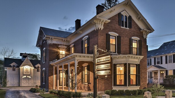 A historic brick building with a porch and a sign reading "Burrell House." - The Burrell House (Keene)