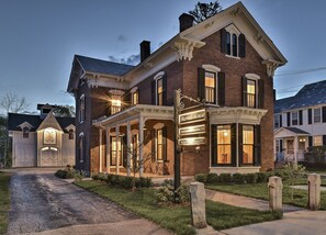 A historic brick building with a porch and a sign reading "Burrell House." - The Burrell House (Keene)