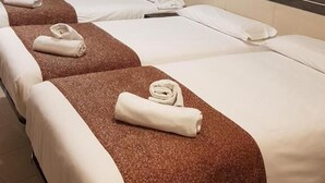 A hotel room with three single beds, each with a brown headboard and white bedding. There is a painting of the Leaning Tower of Pisa on the wall. - Hostal Levante (Barcelona)
