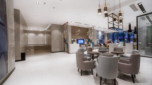 A modern interior with a seating area, a reception desk, and a bar area. - Echarm Hotel (Changde Chaoyang D5 District) (Changde)
