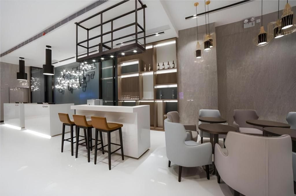 Un interior moderno con una zona de bar, asientos y una lámpara decorativa.