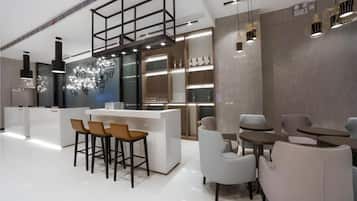 Un interior moderno con una zona de bar, asientos y una lámpara decorativa.