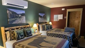Ein Zimmer mit zwei Betten, jedes mit einem einzigartigen Patchwork-Design, einem Holz-Kopfteil und einem Nachttisch mit einer Lampe.