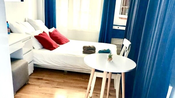 Ein kleines Zimmer mit einem Bett, einem Tisch und einem Stuhl.