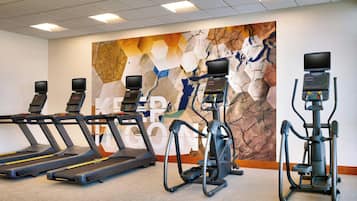 A gym with treadmills, an elliptical, and a stationary bike.