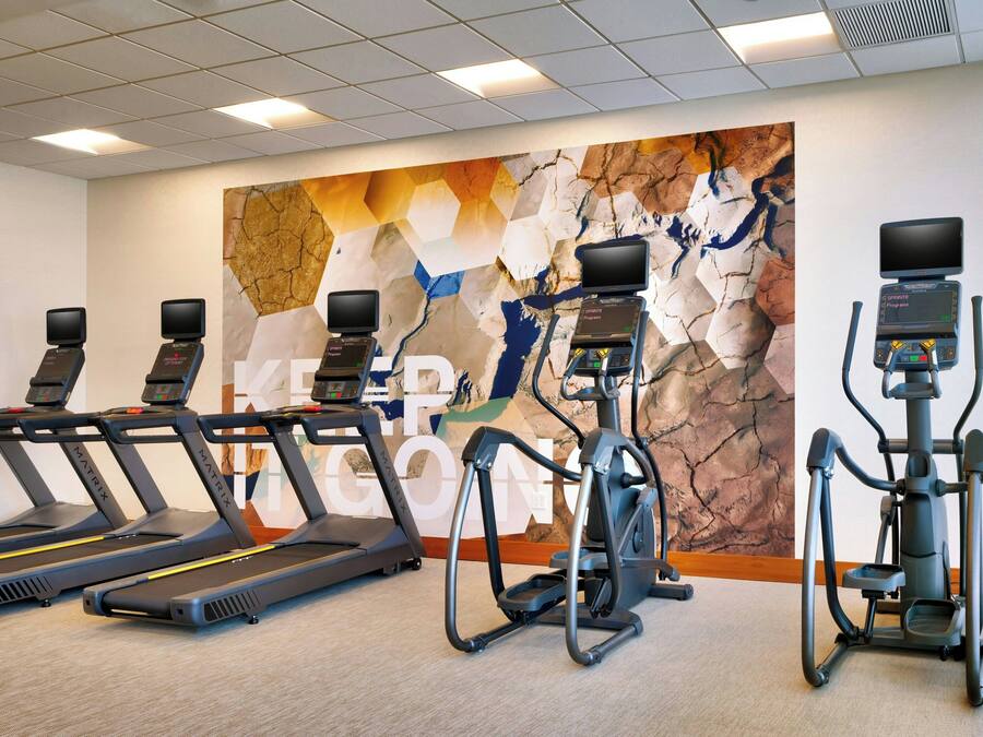 A gym with treadmills, an elliptical, and a stationary bike.