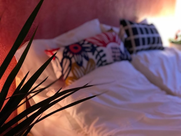 A bed with white bedding and colorful pillows.