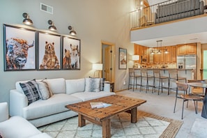 Relax in a comfortable living space with a sofa, coffee table, and framed photographs on the wall.