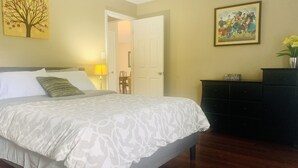 A bedroom with a bed, a dresser, a painting, and a lamp. - Spacious  Home with Incredible Location (Charlotte)