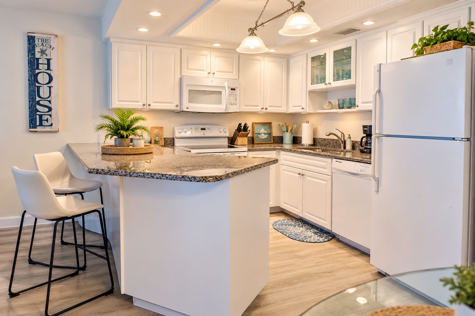 A modern kitchen with white cabinetry, a granite countertop, and a central island.