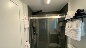 Un baño moderno con ducha envuelta en vidrio, inodoro y lavamanos.