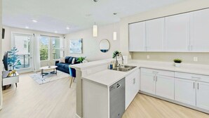 Een modern appartement met keuken, eethoek en zithoek.