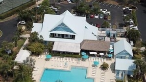 Resort com uma piscina grande, espreguiçadeiras e arquitetura peculiar.
