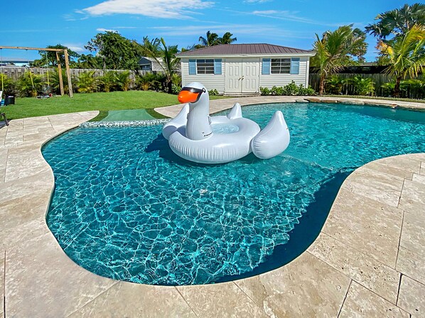A swimming pool with a unique inflatable structure in the center. - Tequesta Beach House, Heated Private Pool, Close to Beach, Sleeps 8 (Jupiter)