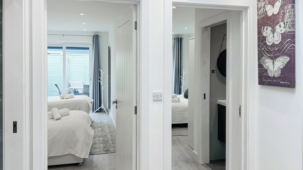 Habitación de hotel con dos camas, baño y vista al exterior.