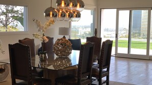 Un comedor moderno con una mesa de vidrio, sillas de madera oscura y un centro de mesa decorativo.