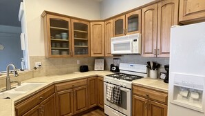 A kitchen with wooden cabinets, a stove, a microwave, and a refrigerator. - Beautiful, cozy home minutes from Laughlin and the river!! (Bullhead City)