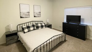 A bedroom with a bed, nightstands, a dresser, a ceiling fan, and two wall-mounted pictures. - Beautiful, cozy home minutes from Laughlin and the river!! (Bullhead City)