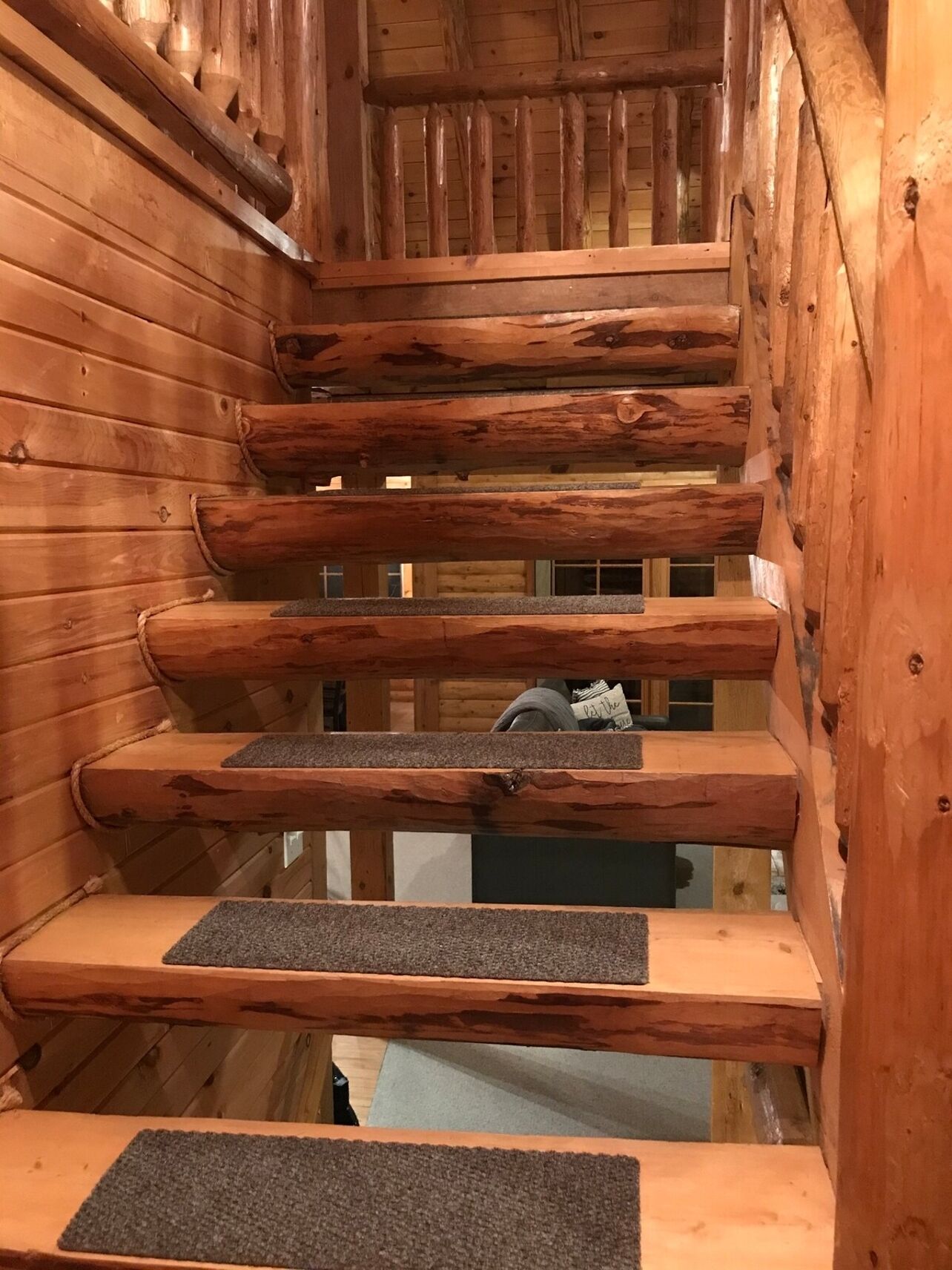A wooden staircase with carpeted steps leading to a higher level.