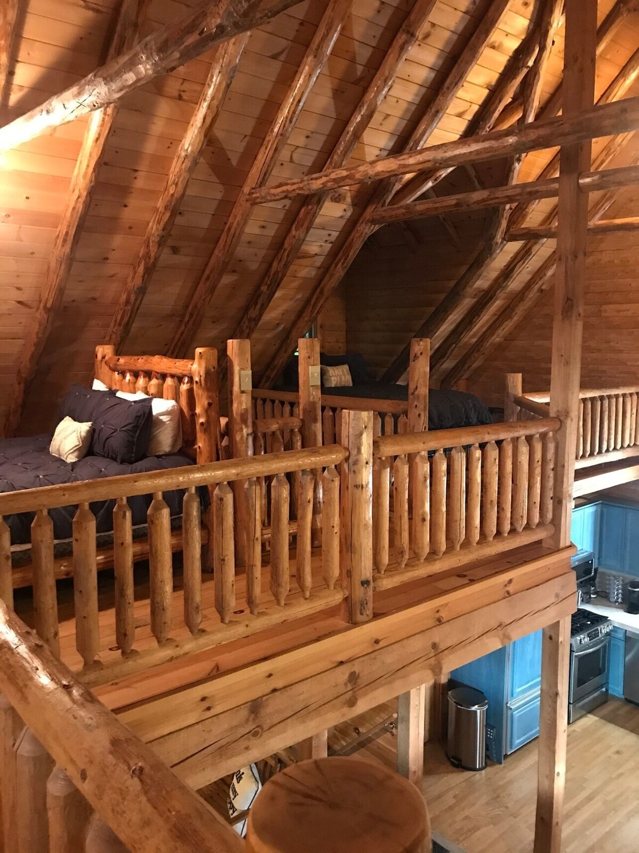 Ein Schlafzimmer im Dachgeschoss mit einem Etagenbett und einem Balkongeländer.