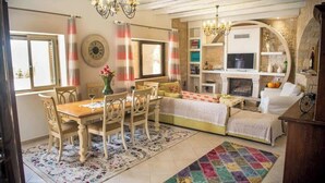 Una sala de estar acogedora con comedor, chimenea y televisor.